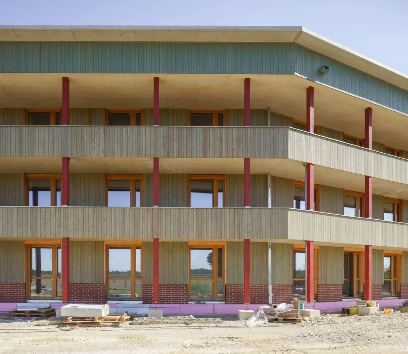 Realisierte Holzfassade mit Balkonen und Fensterflächen.