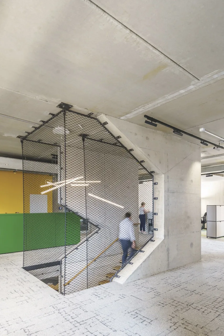 Innere Treppe der RESI als polygonale Betonwandscheibe mit Netz als Absturzsicherung.