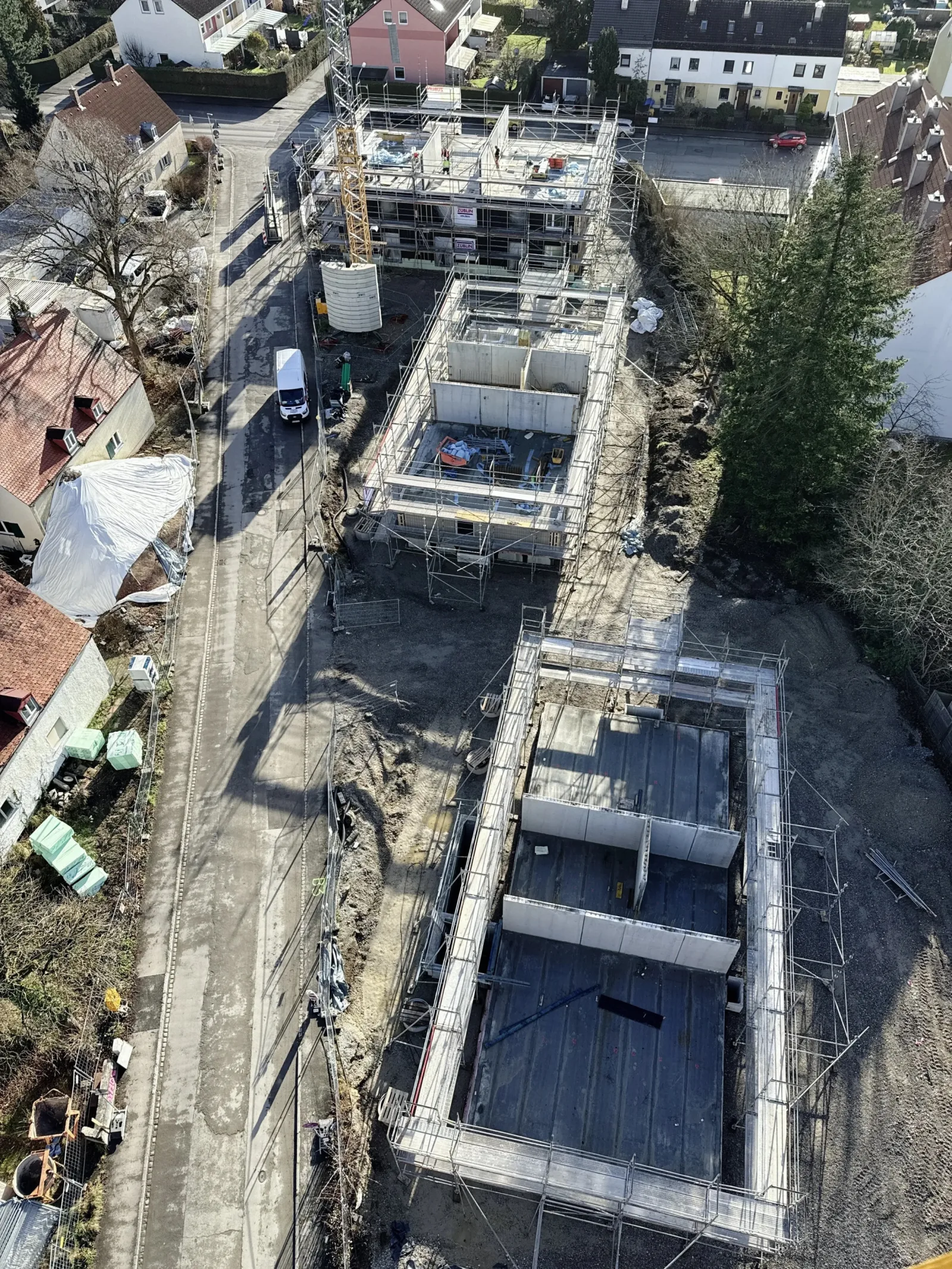 Luftbild der Baustelle mit drei Gebäuden im Rohbau